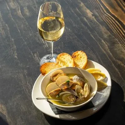 Steamed clams in broth, with baguette, lemon, and white wine.