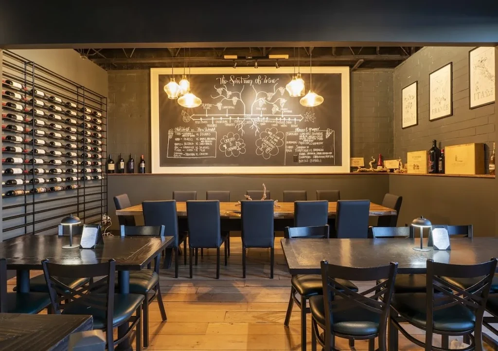 Interior of a sophisticated wine bar with wine racks and chalkboard art.