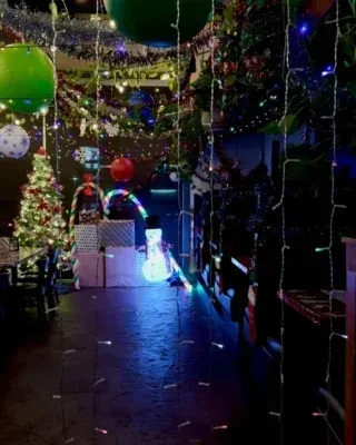 Dimly lit Christmas decor: string lights, tree, snowman, and candy cane.