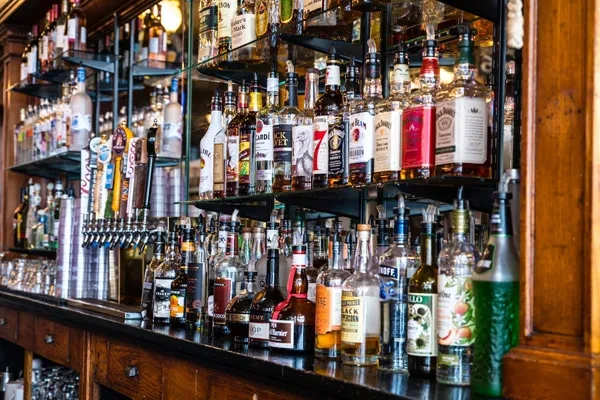 Well-stocked bar with liquor bottles, beer taps, and warm lighting.