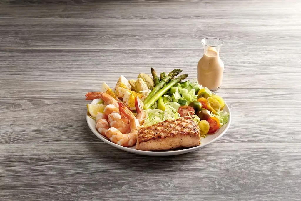 Grilled salmon and shrimp seafood salad with asparagus and tomatoes.
