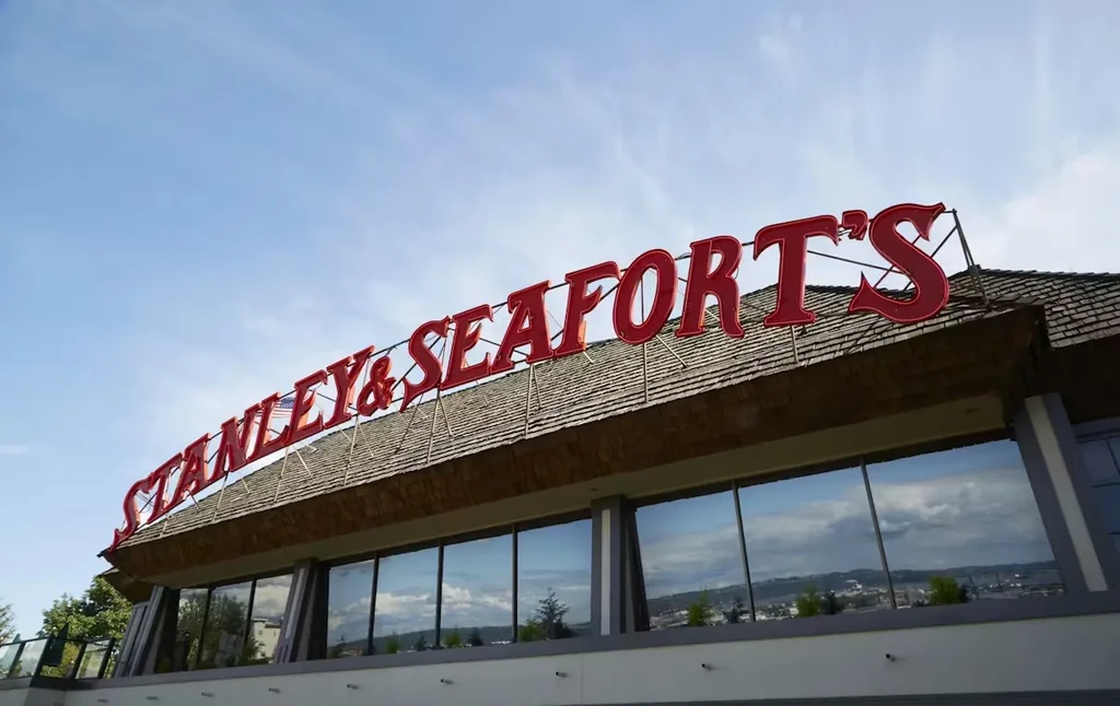 Stanley & Seafort's building: red sign, shingle roof, reflective windows, blue sky.