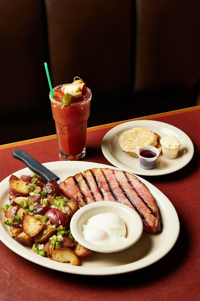 Breakfast with grilled ham, roasted potatoes, poached eggs, and Bloody Mary.