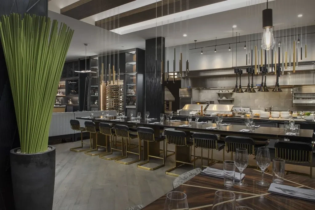 Modern upscale restaurant interior with an open kitchen and bar area.