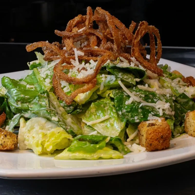 Caesar salad with romaine, creamy dressing, Parmesan, crispy fried onions, and croutons.
