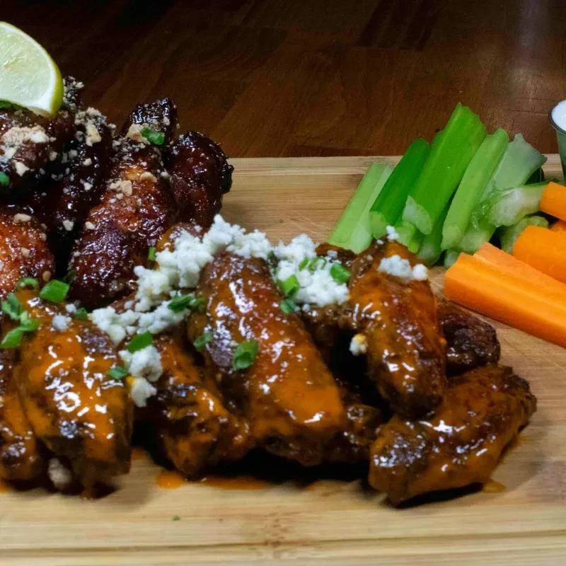 Glazed and buffalo chicken wings with blue cheese, celery, and carrots.