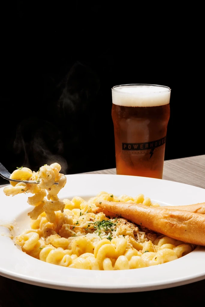 Fork lifts steaming mac and cheese, breadstick, Powerhouse beer.