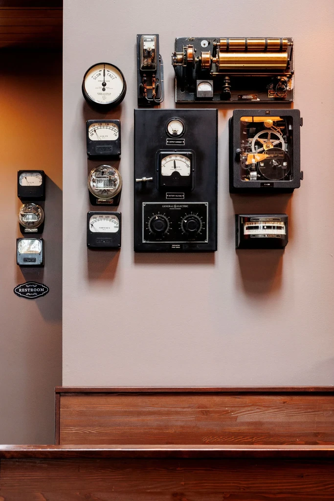 Eclectic wall decor with vintage meters, gauges, and a RESTROOM sign.