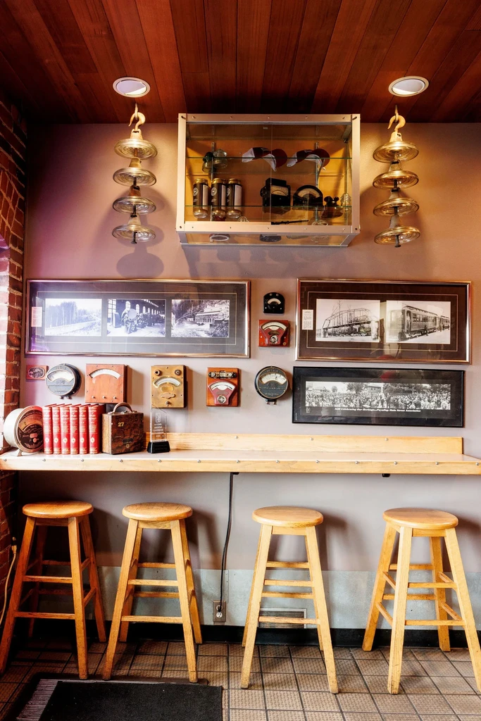 Restaurant bar counter with four stools and industrial vintage wall decor.