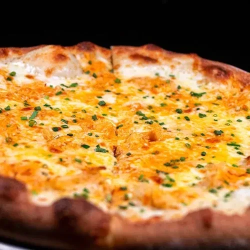 Freshly baked cheese pizza with green herbs and golden crust.