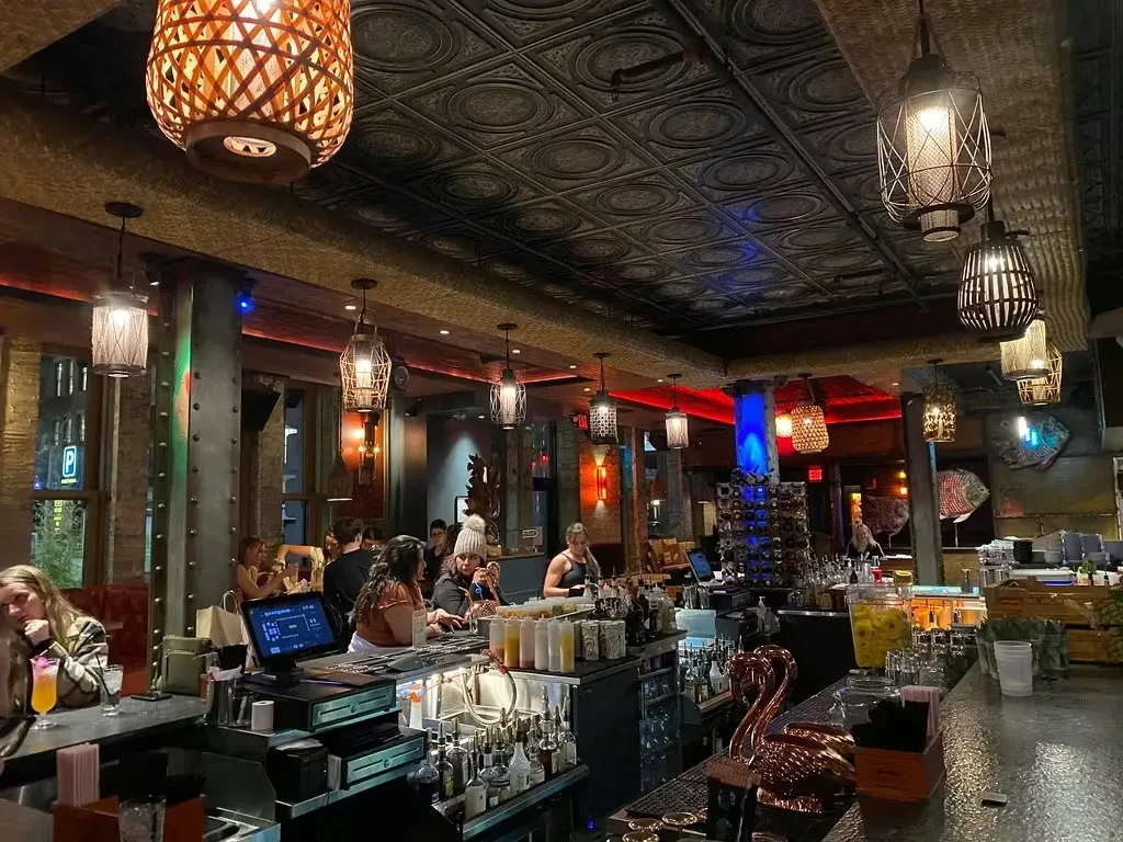 Ornate, dimly lit bar interior featuring lanterns and a copper flamingo.