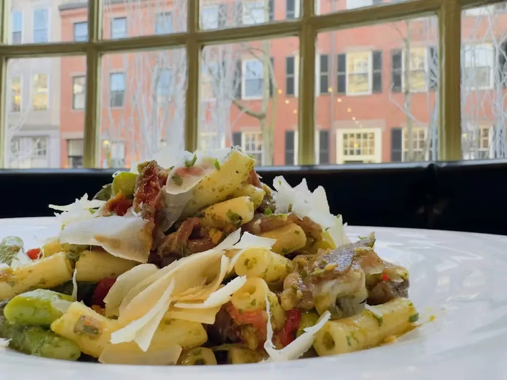 Short pasta with green sauce, meat, sun-dried tomatoes, Parmesan, and herbs.
