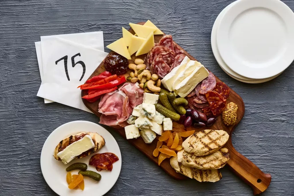 Wooden charcuterie and cheese board laden with meats, cheeses, and fruits.