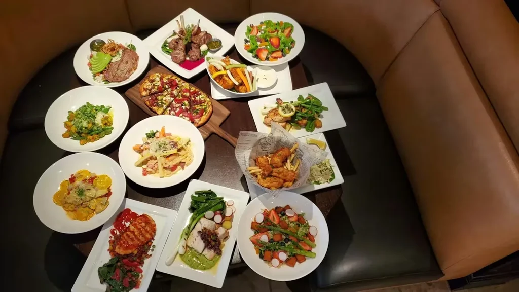 Overhead view of a large diverse food spread on a restaurant table.