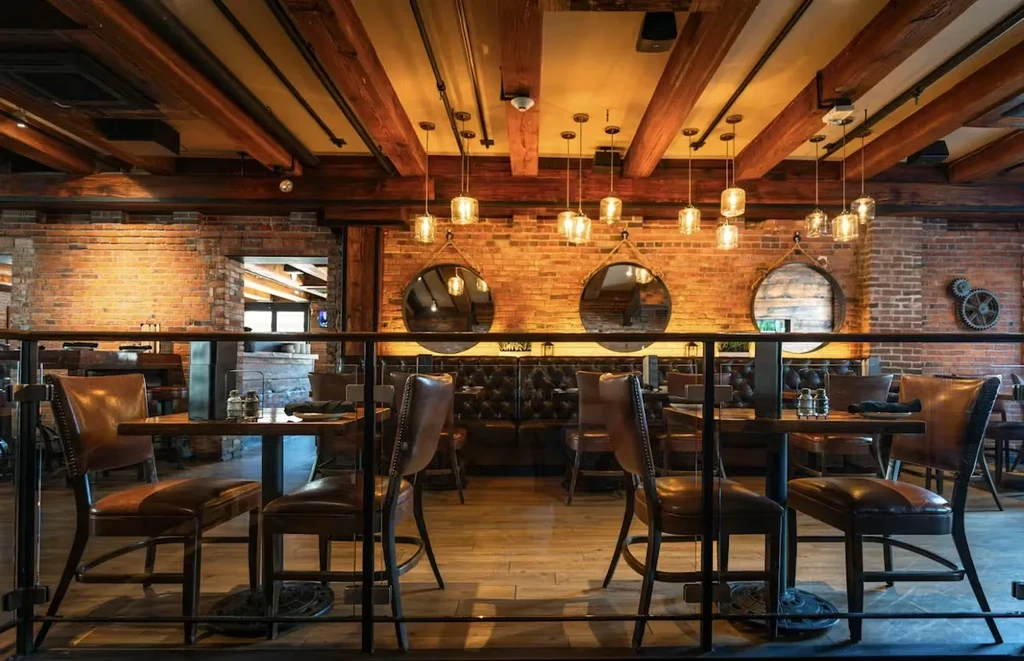 Empty industrial-style restaurant with brick walls and leather seating.