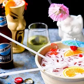 Frothy punch bowl, Blue Moon beer, tiki mug, and other drinks.