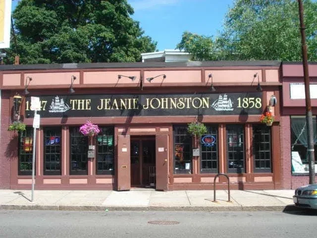 Exterior of The Jeanie Johnston pub with colorful hanging flowers.
