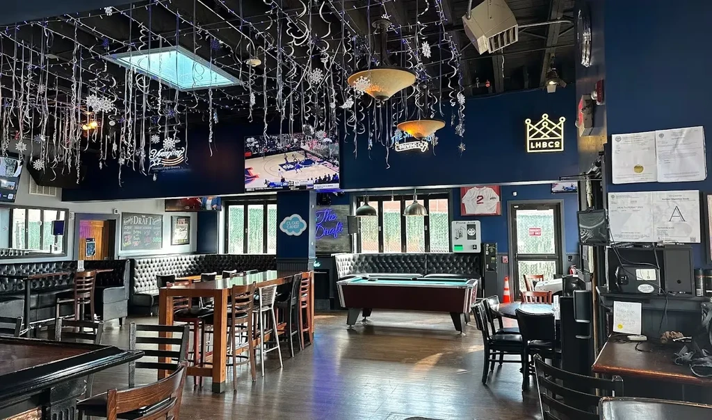 Empty festive sports bar interior with TVs and a pool table.