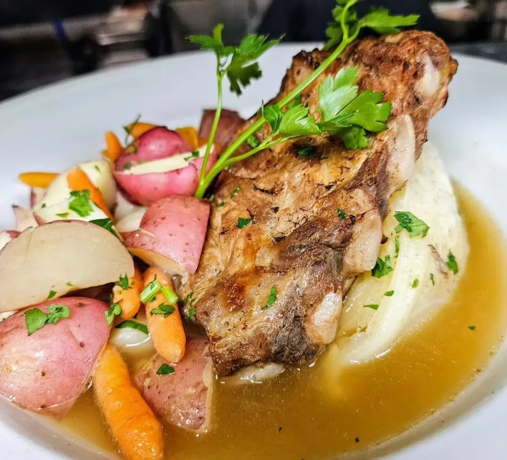 Golden-brown seared short rib with potatoes, carrots, and gravy.
