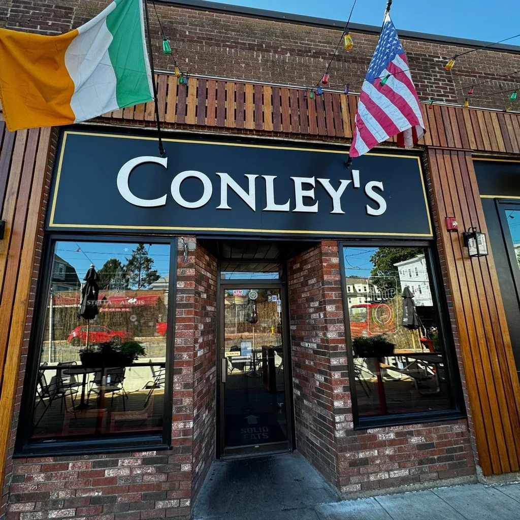 Conley's restaurant exterior, brick, wood, string lights, Irish and American flags.