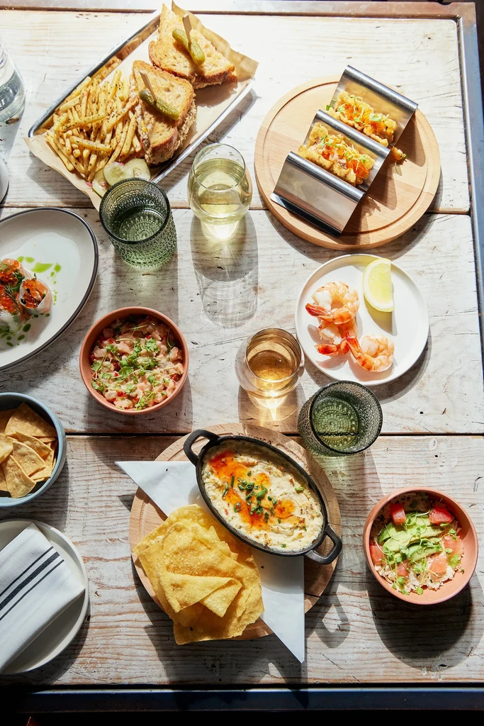 Top-down view of a rustic table with diverse plated dishes and drinks.