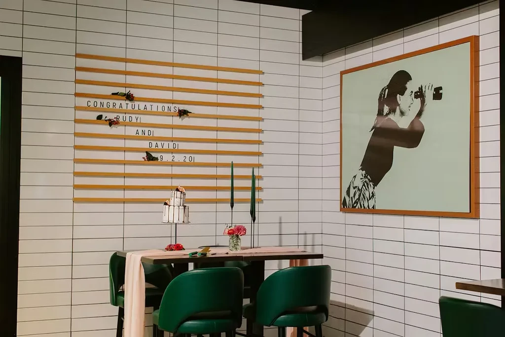 Modern tiled space with "CONGRATULATIONS RUDY AND DAVID" sign and cake.