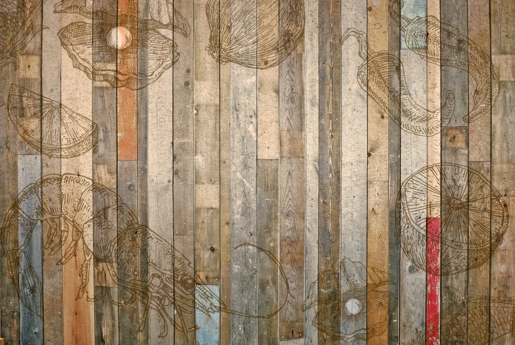 Rustic wooden wall featuring line drawings of seafood, citrus, and peppers.