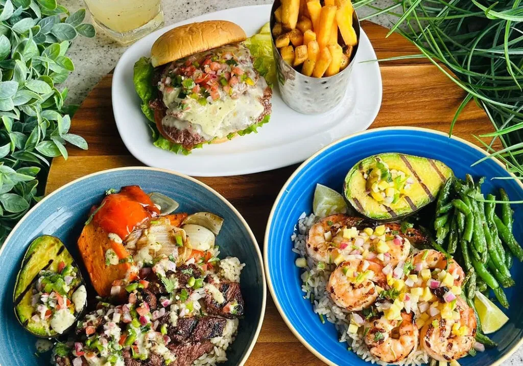 Overhead view of a burger, steak bowl, shrimp bowl, and drink.