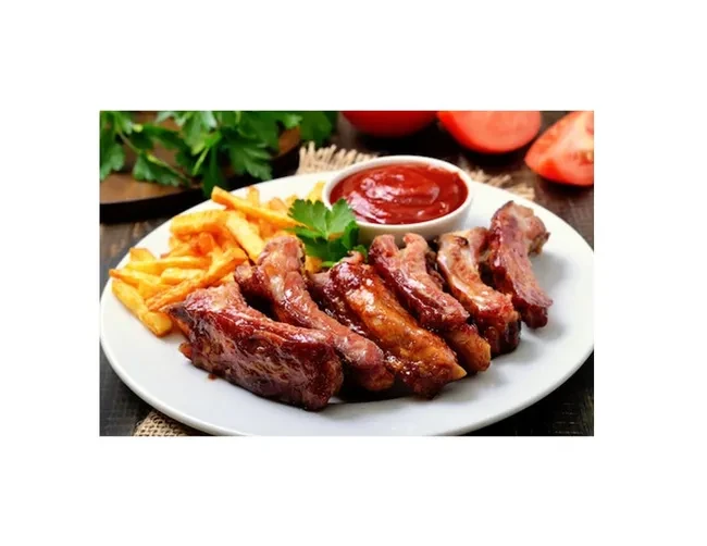 Plate of glistening grilled ribs, golden fries, and ketchup with parsley.