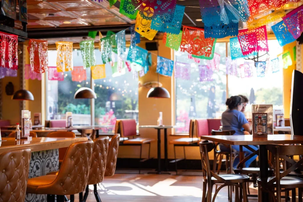 Bright, festive Mexican restaurant interior with colorful papel picado.