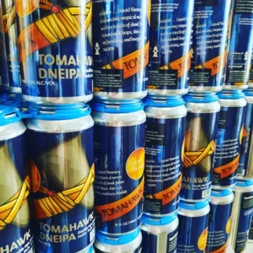 Stack of dark blue "TOMAHAWK DNEIPA" craft beer cans.