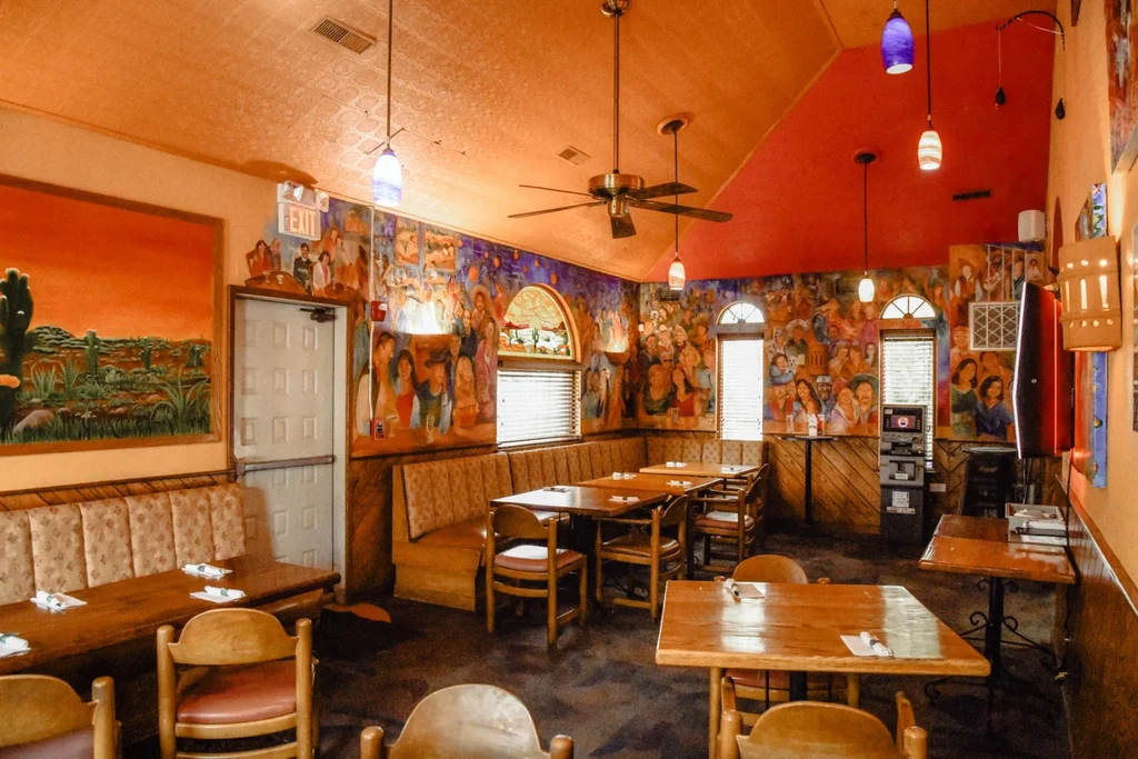Casual restaurant interior with extensive colorful wall murals.