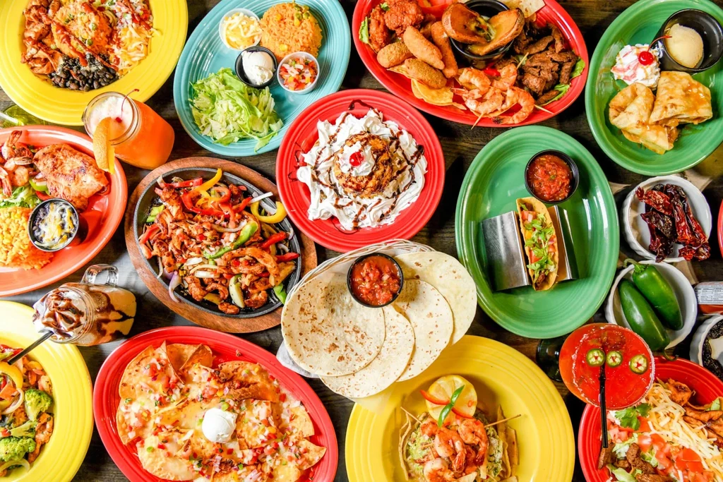 Vibrant, overhead view of many Mexican and Tex-Mex dishes and drinks.
