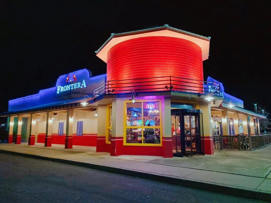 Frontera Tacos & Tequila restaurant exterior, lit by blue and red neon.