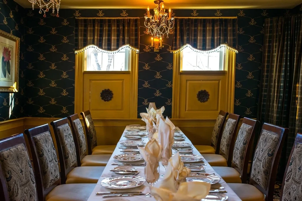 Ornate blue and gold dining room with a long, set table.
