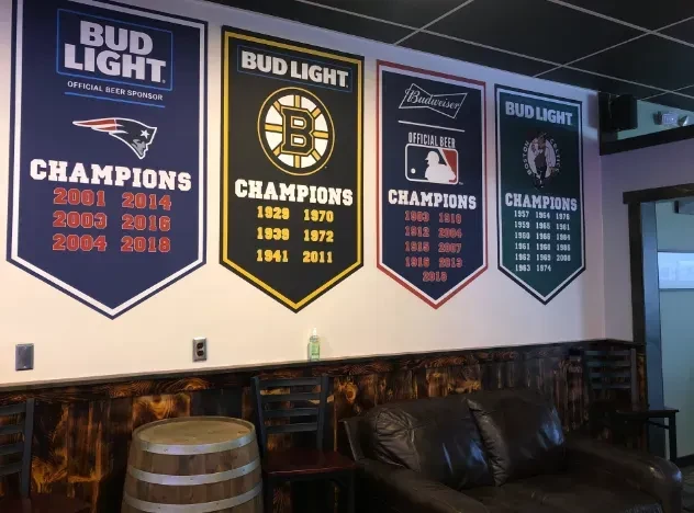 Championship banners for Boston's Patriots, Bruins, Red Sox, Celtics in a bar.