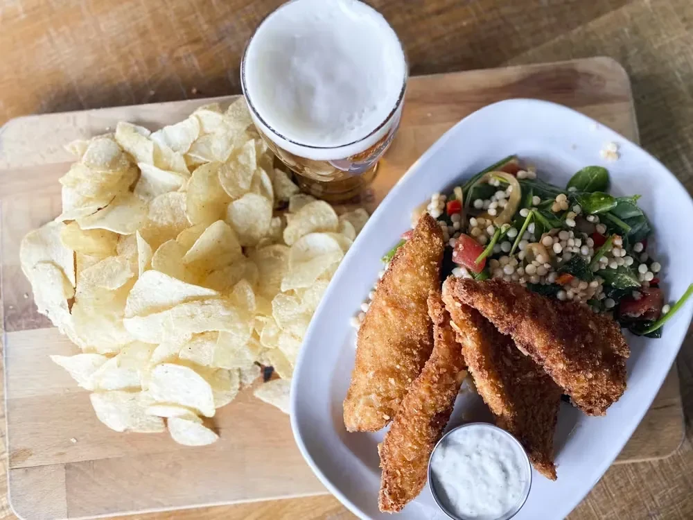 Fried food, crinkled chips, pasta salad, dipping sauce, and beer.