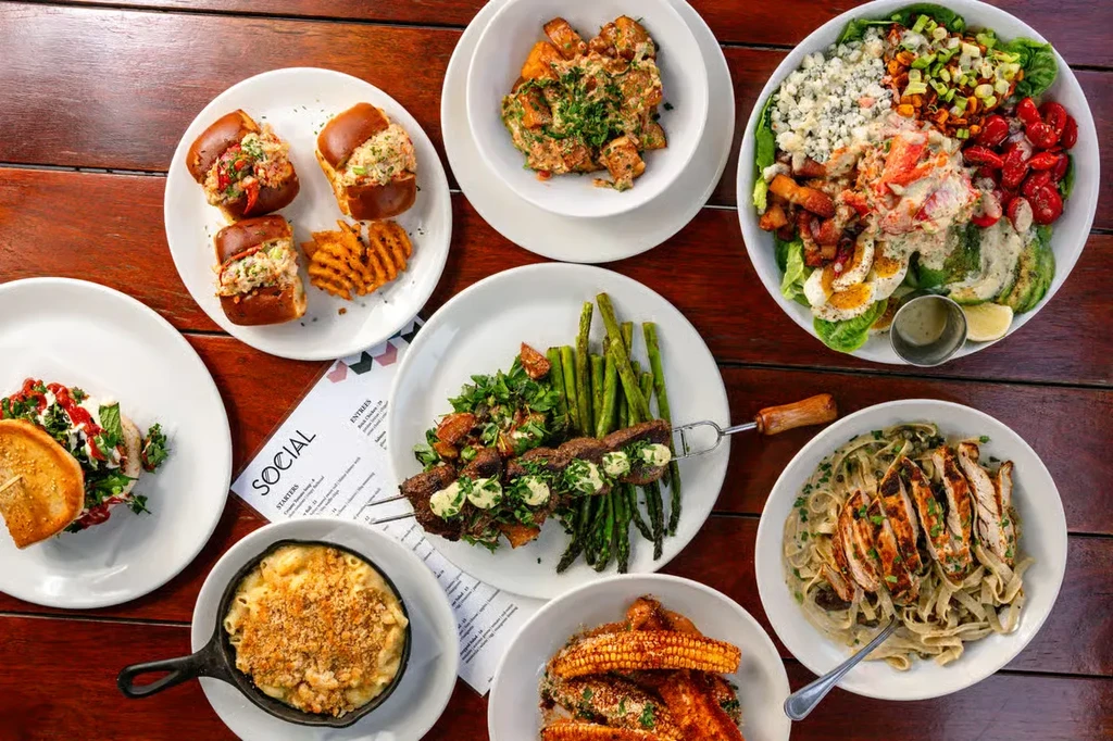 Flat lay of various meticulously prepared restaurant dishes and a menu.