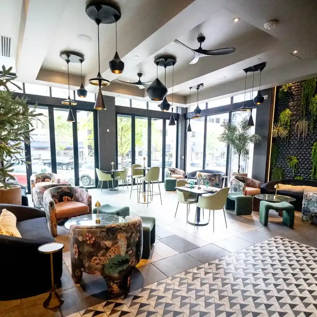 Modern restaurant lounge with eclectic seating, vertical garden, and city views.