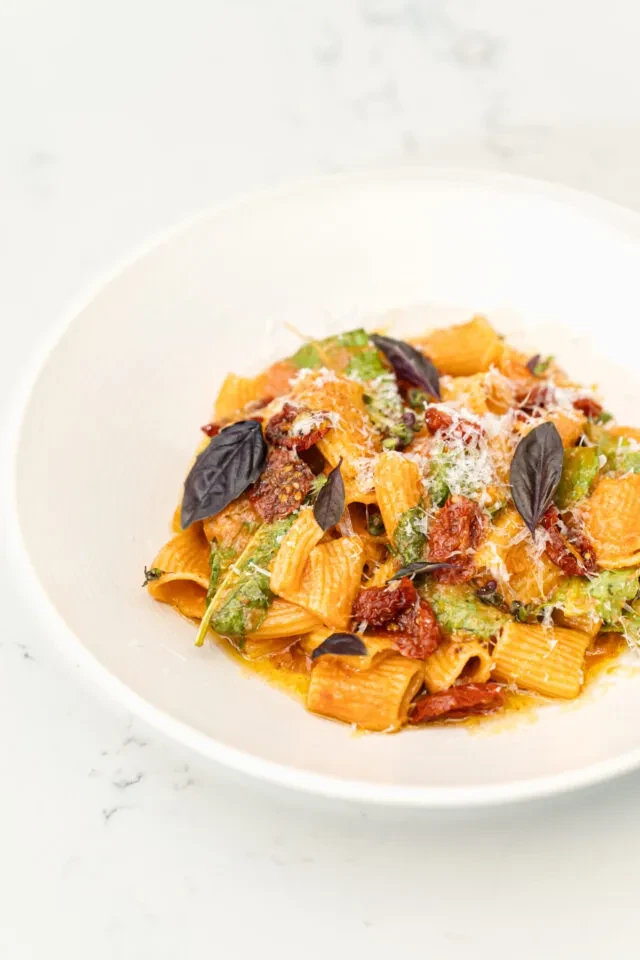 Rigatoni with red sauce, sun-dried tomatoes, greens, cheese, and basil.