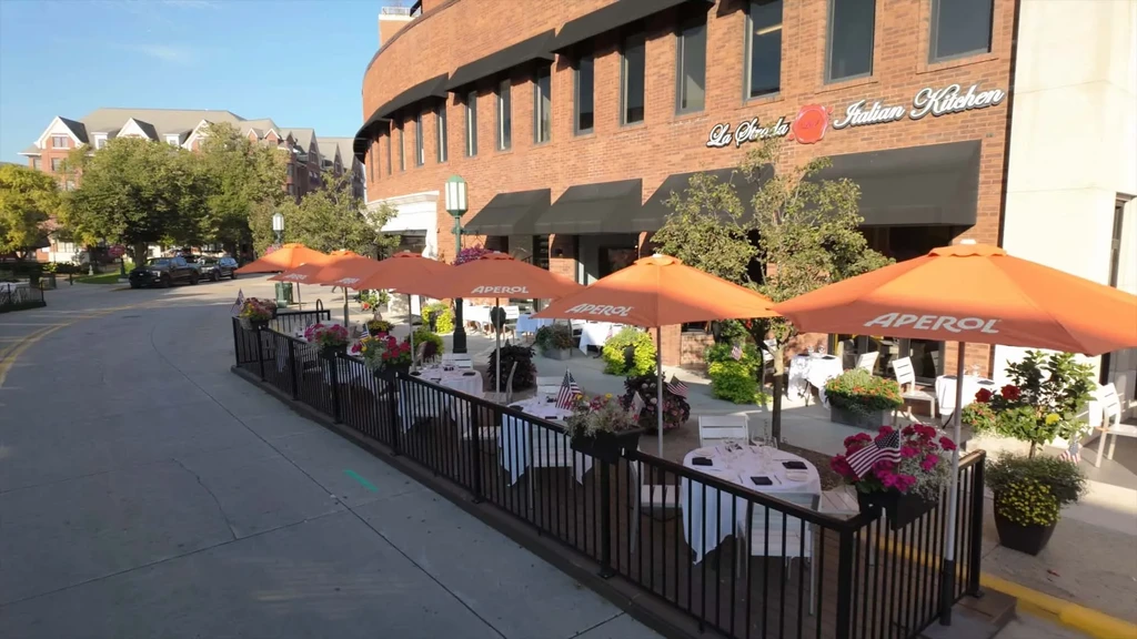La Strada Italian Kitchen outdoor patio with orange Aperol umbrellas, flower boxes.