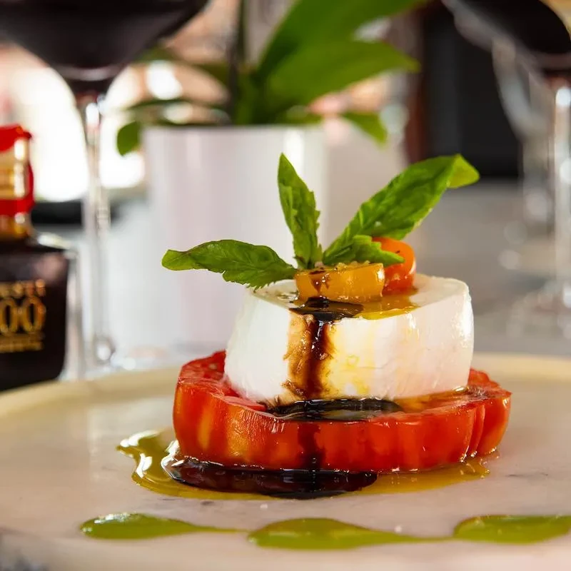 Caprese salad with tomato, mozzarella, basil, olive oil, balsamic, cherry tomatoes.