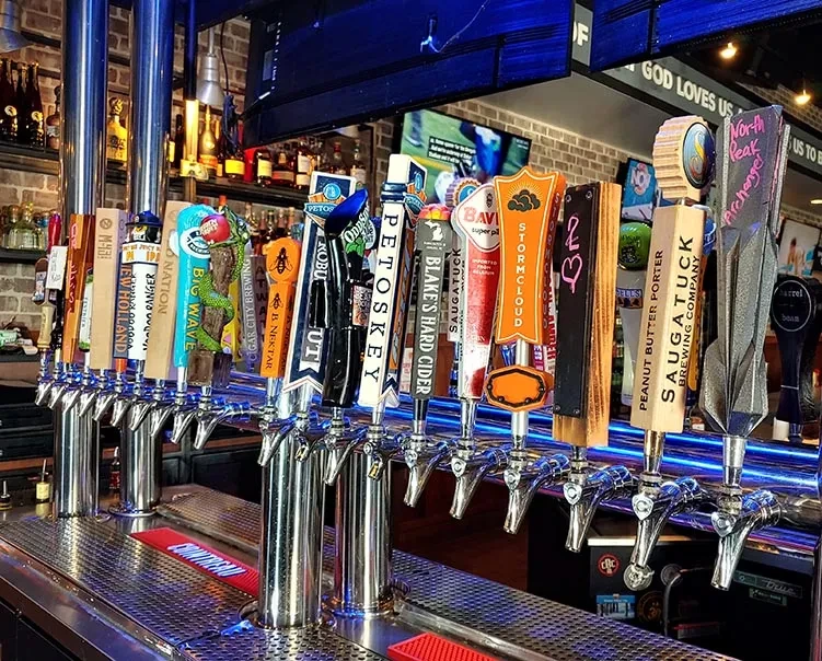 Twenty-five diverse beer and cider taps at a modern bar.