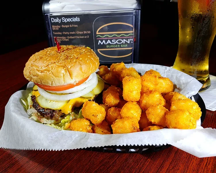 Stacked cheeseburger, crispy tater tots, served in a basket at Mason's.
