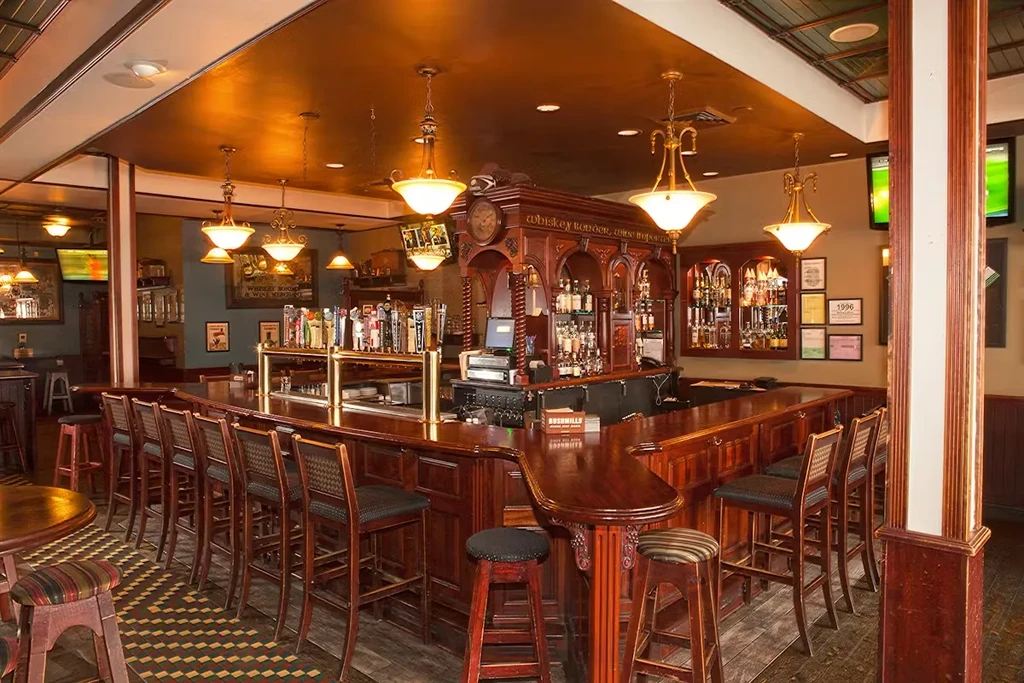 Ornate wooden bar interior with spirits, beer taps, and classic decor.