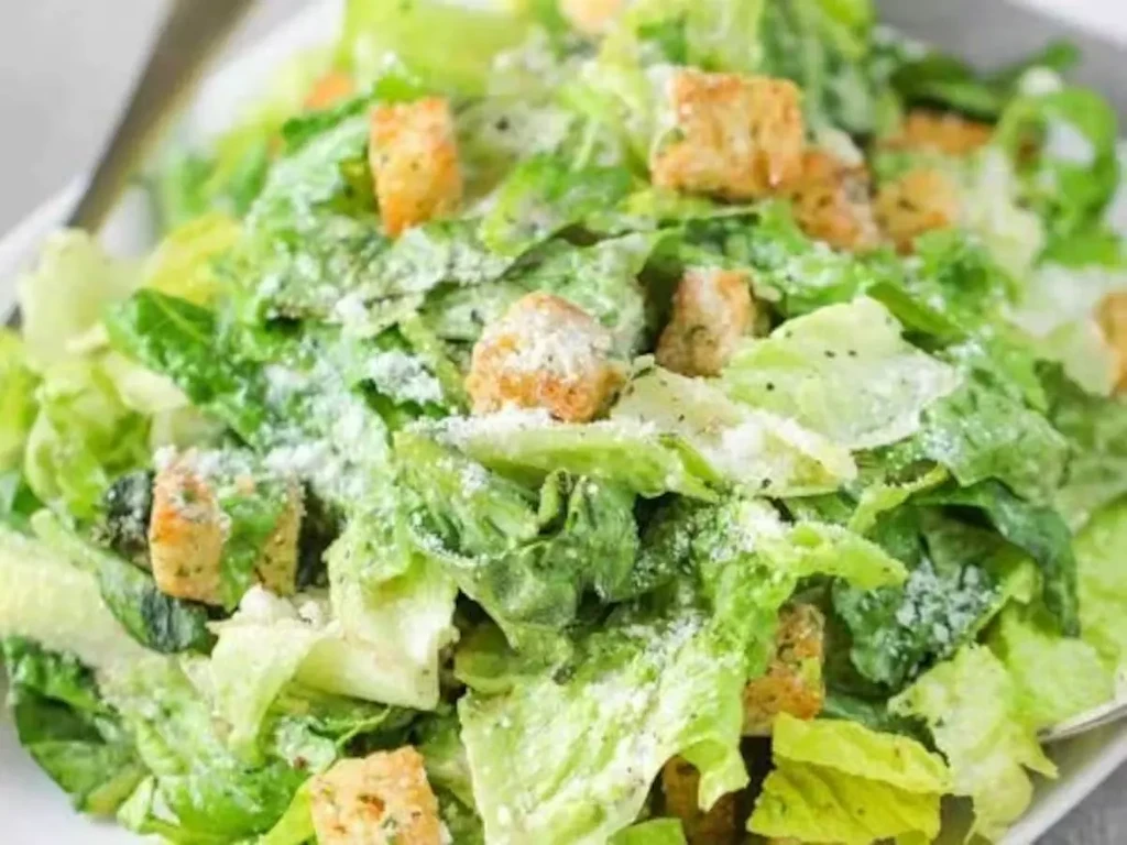 Fresh Caesar salad with romaine, croutons, grated cheese, and dressing.