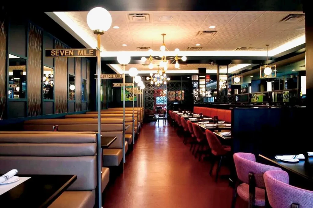 Empty modern restaurant interior with booths, banquet seating, street sign decor.