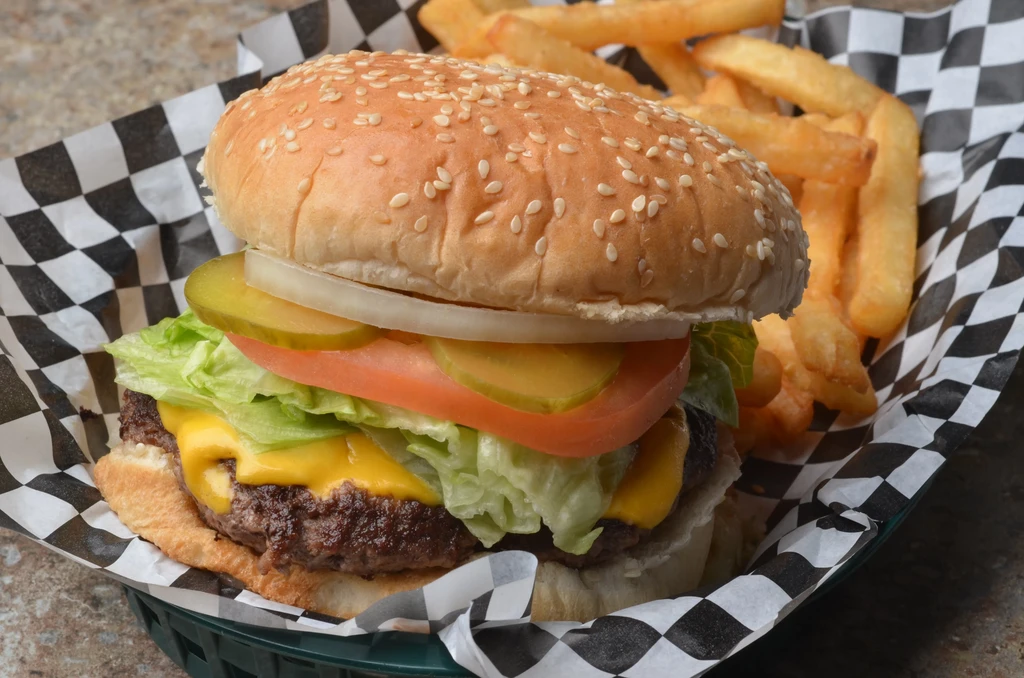 Classic cheeseburger with lettuce, tomato, onion, pickle, and golden fries.