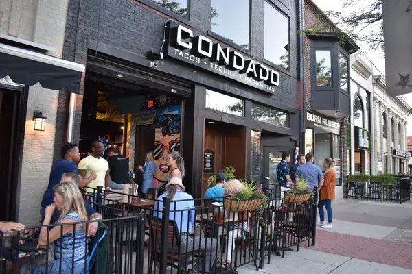 CONDADO Tacos restaurant exterior on a busy urban street with outdoor patio.
