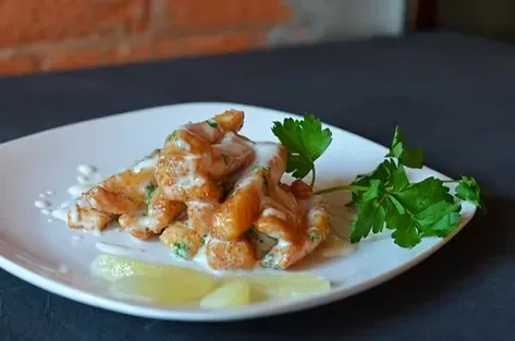 Pan-seared chicken/fish with creamy herb sauce, lemon, and parsley.